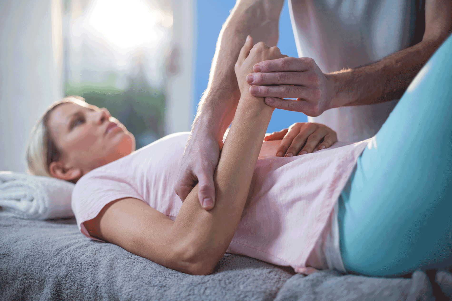 Physiotherapist massaging hand of a female patient 