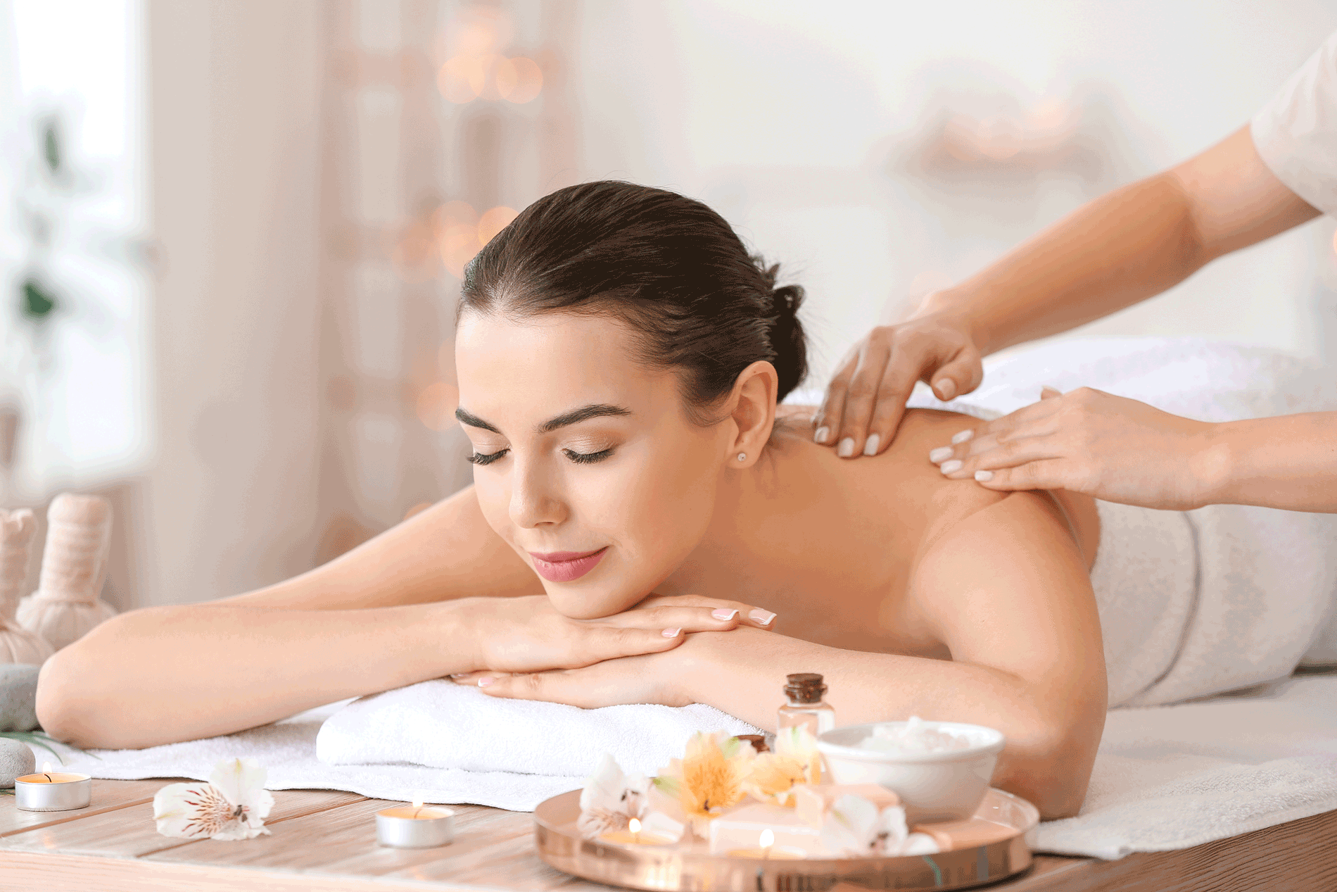 Beautiful young woman receiving massage in spa salon